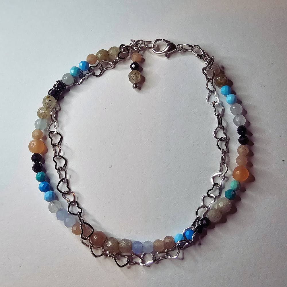 Handgefertigtes Edelsteinarmband mit Mondstein, Türkis, Aquamarin und Blaufluss – zartes Damenarmband mit fix montierter Edelstahl-Herzkette, das Ruhe, Harmonie und Leichtigkeit ausstrahlt.