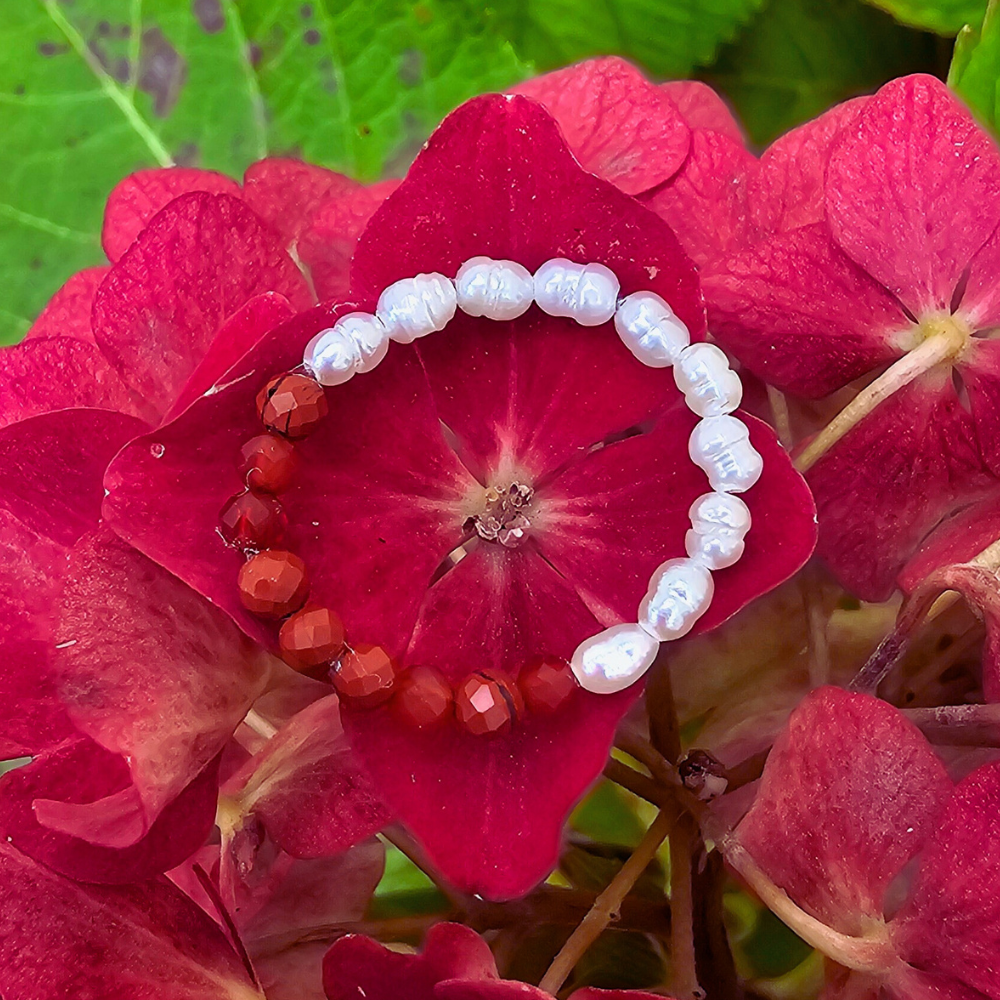 Edler Damenring mit natürlichen Edelsteinen und glänzenden Süßwasserperlen.