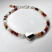 Edelsteinarmband mit Karneol, rotem Jaspis, Sonnenstein, Mondstein, Granat und Süßwasserperlen, mittig ein schwarzes Herz-Element, warmes Armband im Minimal-Look.
