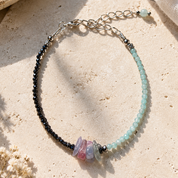Handgefertigtes Edelsteinarmband mit facettiertem Amazonit, facettiertem Hämatit und natürlichem Fluorit auf hellem Hintergrund.