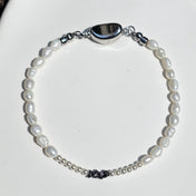 Entdecke das handgefertigte Rohdiamant Armband White Aura mit natürlichen schwarzen Rohdiamanten, schimmerndem Perlmutt und echten Süßwasserperlen.