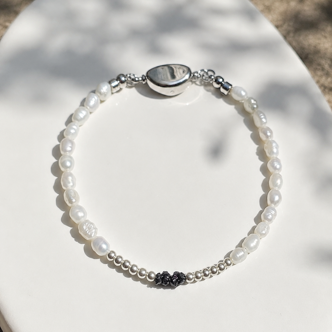 Entdecke das handgefertigte Rohdiamant Armband White Aura mit natürlichen schwarzen Rohdiamanten, schimmerndem Perlmutt und echten Süßwasserperlen.