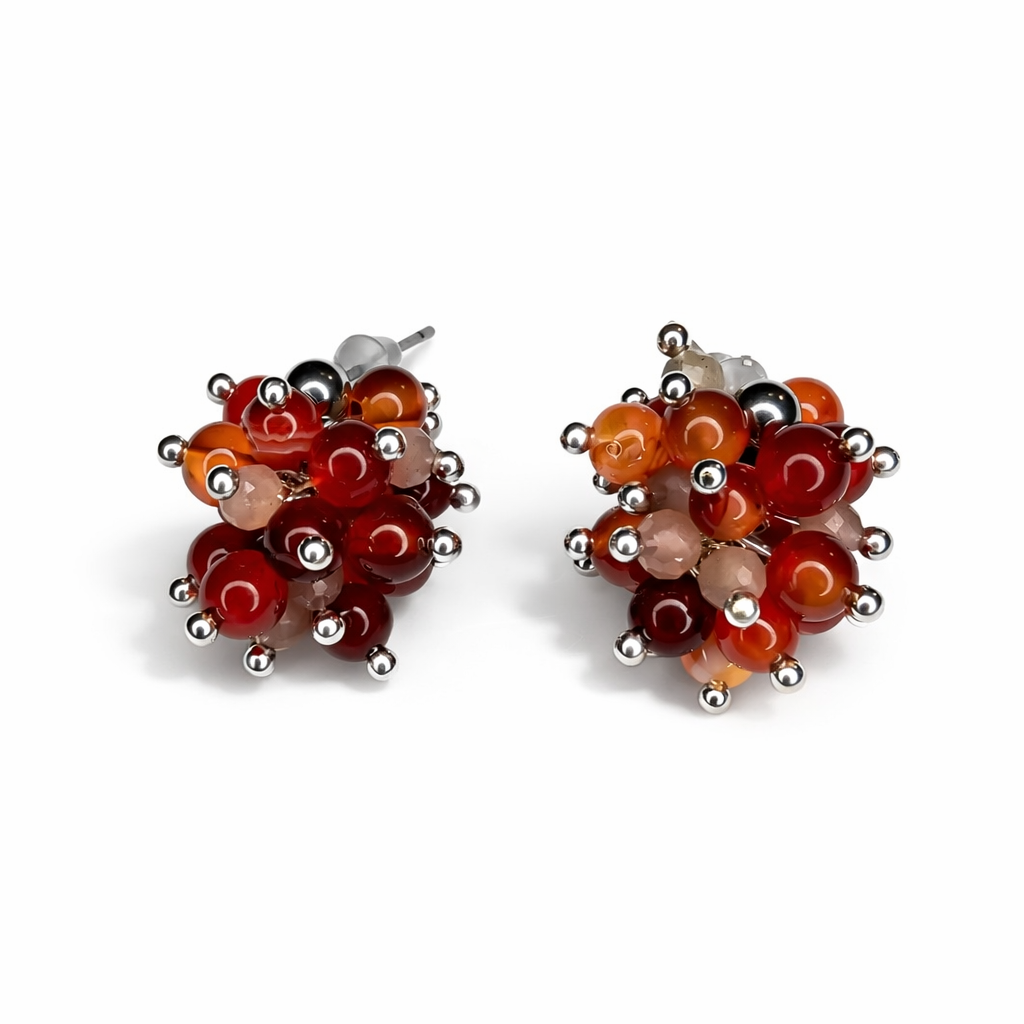 Handgefertigte Cluster-Ohrstecker aus Karneol und Mondstein mit Edelstahl-Details, warme Rot- und Orangetöne, minimalistisches Design, Studioaufnahme auf weißem Hintergrund mit weichem Schatten.
