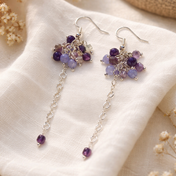 Handgefertigte Edelstein Ohrringe mit Amethyst, Aquamarin und Fluorit an silberfarbener Edelstahlkette, arrangiert auf hellem Leinenstoff in sanften Erdtönen