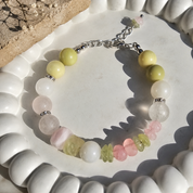 Handgefertigtes Armband mit grüner und weißer Jade, zartem Rosenquarz, Prehnit, Fluorit und Bergkristall auf hellem Hintergrund