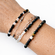 Handgefertigtes Edelsteinarmband-Set mit Onyx, Obsidian, Bergkristall, Mondstein und Granat am Handgelenk.