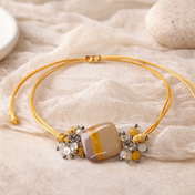 Handgefertigtes Edelsteinarmband „Golden Harmony“ mit Mookait, Fluorit und Perlmutt an zartem gelbem Stoffband in warmen, harmonischen Naturtönen.