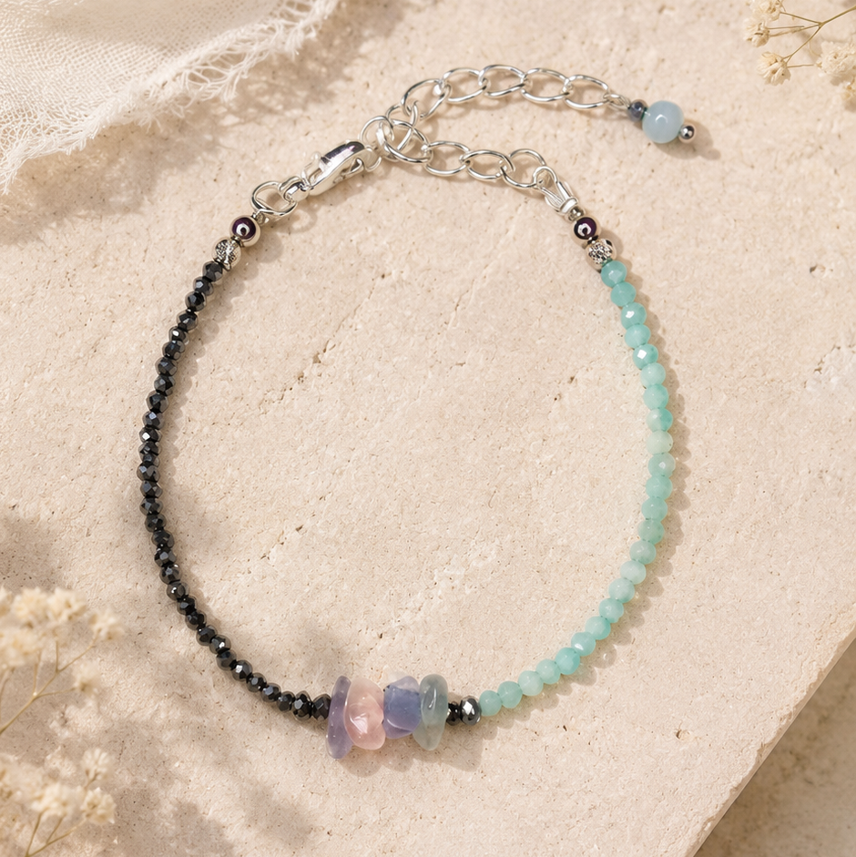 Handgefertigtes Edelsteinarmband mit facettiertem Amazonit, facettiertem Hämatit und natürlichem Fluorit auf hellem Hintergrund.