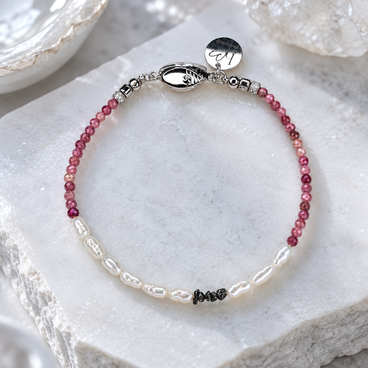 Raw Diamond Romance Edelsteinarmband auf hellem Stein arrangiert – Rhodolith-Granat, fünf schwarze Rohdiamanten und Süßwasserperlen