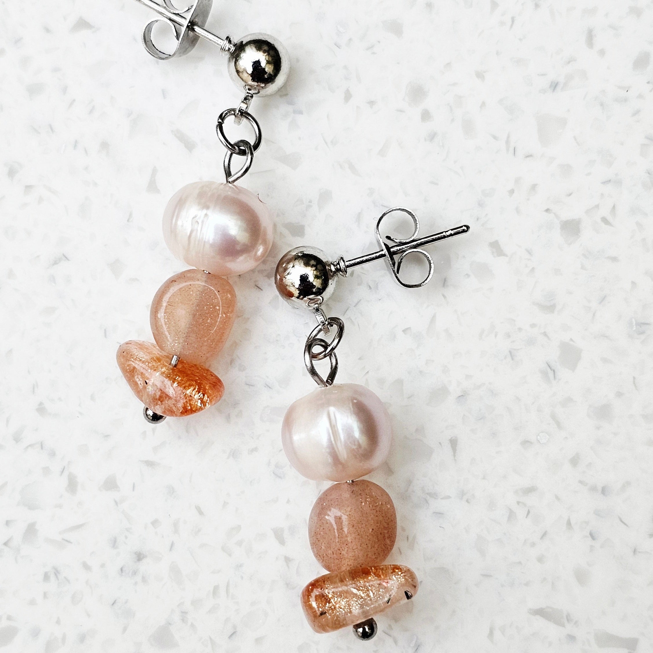 Detailansicht der Pearl Sage Sunkissed Ohrringe mit warmem Sonnenstein und echten Süßwasserperlen